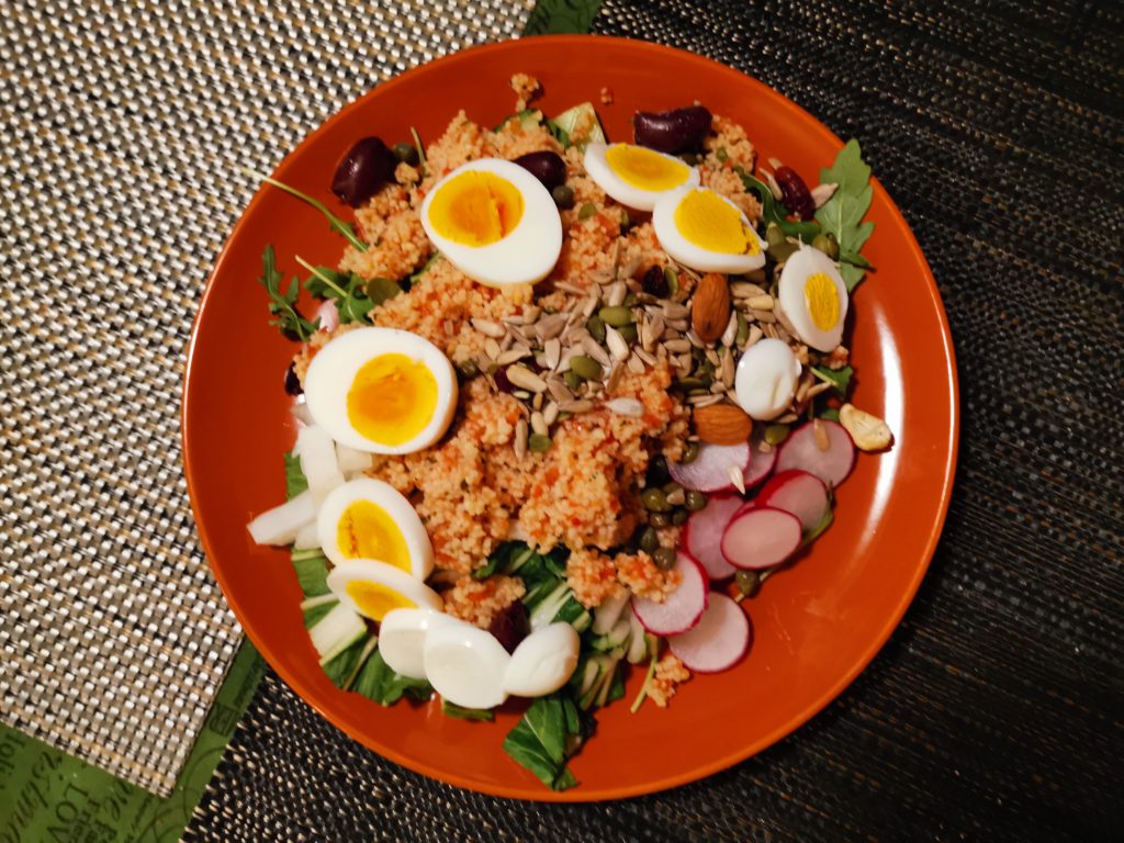 orange plate with salad on it. 